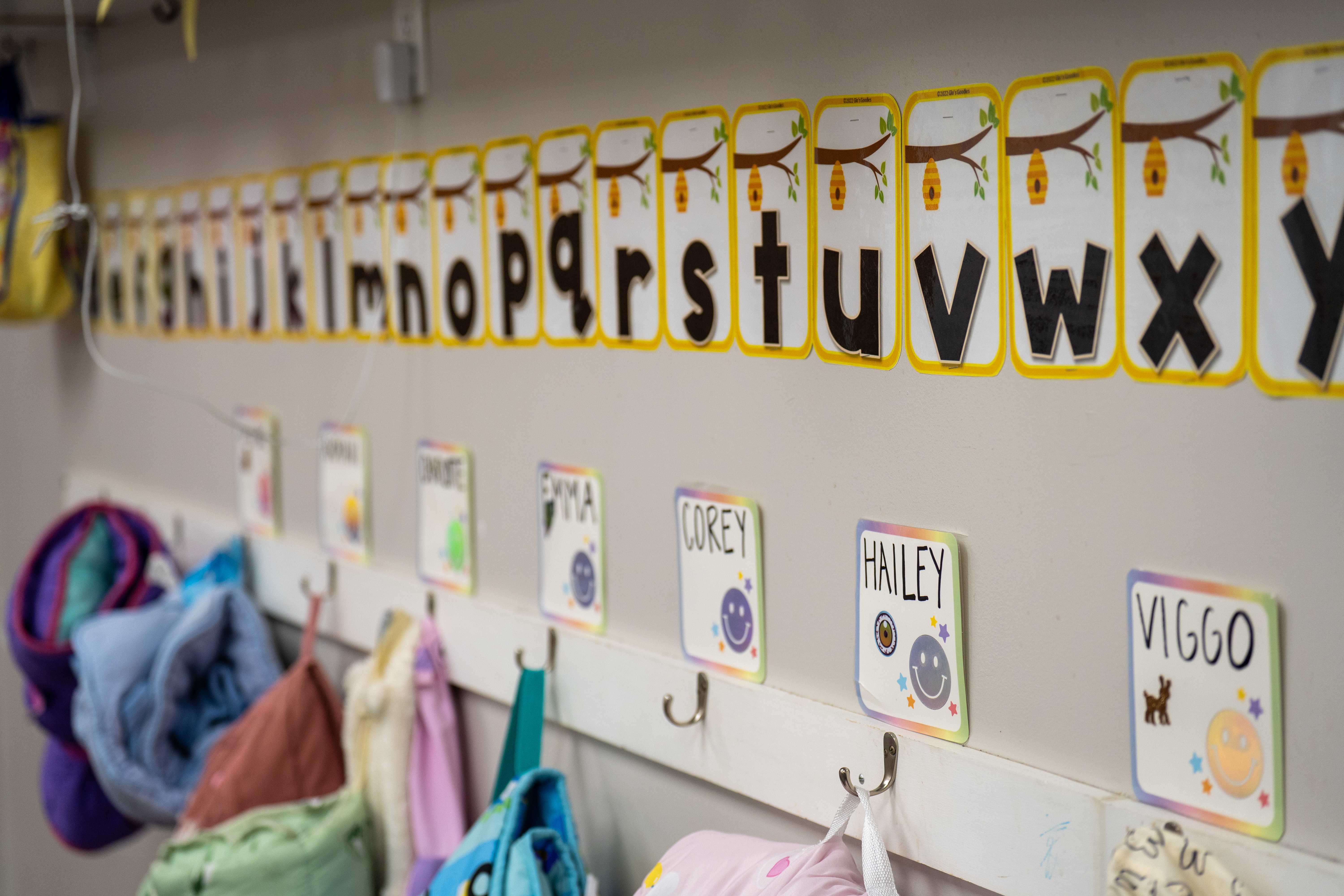 Classroom cubbies with children's name cards and alphabet display